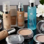 Cruelty-free makeup for oily skin: foundations, powders, and setting sprays on a black surface.